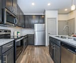kitchen with electric range oven, stainless steel appliances, dark brown cabinetry, light granite-like countertops, pendant lighting, and dark hardwood flooring, The Retreat At Barbers Hill