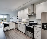 kitchen featuring natural light, stainless steel appliances, ventilation hood, electric range oven, white cabinetry, light hardwood floors, and light countertops, Green on Fourth