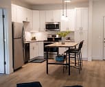 kitchen with range oven, refrigerator, dishwasher, stainless steel microwave, white cabinetry, light hardwood flooring, pendant lighting, and light countertops, The Approach at Summit Park