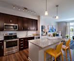 kitchen featuring a kitchen breakfast bar, a kitchen island, stainless steel microwave, electric range oven, dishwasher, refrigerator, light granite-like countertops, dark parquet floors, pendant lighting, and dark brown cabinetry, Woodfall Greens