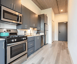kitchen featuring stainless steel microwave, gas range oven, dishwasher, refrigerator, light countertops, dark brown cabinets, and light hardwood flooring, X Chicago