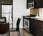 kitchen with stainless steel microwave, refrigerator, gas range oven, dark brown cabinetry, dark hardwood floors, and dark countertops, The Dylan on Fifth