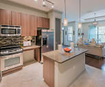 kitchen featuring a center island, natural light, electric range oven, stainless steel appliances, granite-like countertops, brown cabinets, pendant lighting, and light tile flooring, Bell Vinings