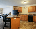 kitchen featuring a breakfast bar, refrigerator, dishwasher, range oven, dark tile flooring, dark granite-like countertops, and brown cabinets, Fox Run Apartments