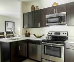 kitchen featuring electric range oven, stainless steel appliances, dark brown cabinetry, light flooring, and light countertops, Sterling Parc At Hanover