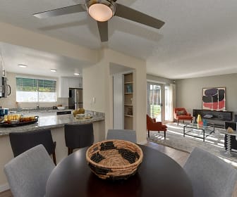 kitchen with a ceiling fan, a healthy amount of sunlight, refrigerator, stone countertops, white cabinets, and light flooring, West Oaks Apartments