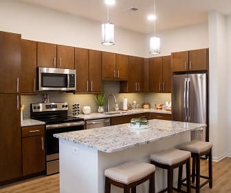 kitchen with electric range oven, stainless steel appliances, dark brown cabinets, pendant lighting, light stone countertops, and light parquet floors, The Residences at Park Place