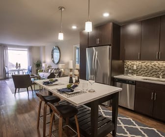 kitchen featuring natural light, stainless steel appliances, dark brown cabinets, light countertops, pendant lighting, and light hardwood flooring, Union West