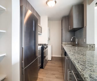 kitchen with refrigerator, microwave, gas range oven, dark brown cabinetry, light granite-like countertops, and dark hardwood flooring, Iris Apartments
