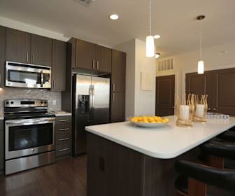 kitchen featuring a breakfast bar area, electric range oven, stainless steel appliances, light countertops, dark parquet floors, pendant lighting, and dark brown cabinets, Olympus Grand Crossing