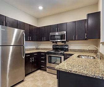 kitchen with stainless steel appliances, electric range oven, light tile flooring, dark brown cabinetry, and dark stone countertops, Reserve at Southpointe