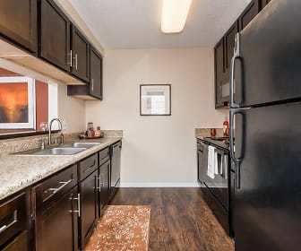 kitchen featuring refrigerator, dishwasher, range oven, dark hardwood floors, light stone countertops, and dark brown cabinetry, Tuscany Pointe