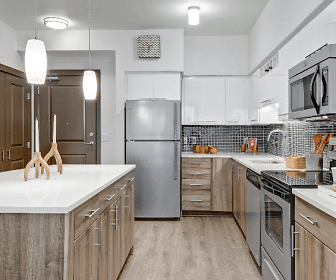 kitchen with a center island, stainless steel appliances, electric range oven, white cabinetry, pendant lighting, light parquet floors, and light countertops, Tessera Apartments