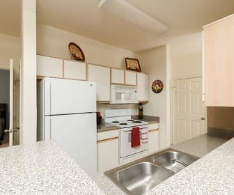 kitchen with refrigerator, electric range oven, microwave, white cabinetry, light stone countertops, and light flooring, Villa du Lac