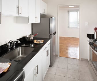 kitchen featuring natural light, refrigerator, gas range oven, dishwasher, stainless steel microwave, dark granite-like countertops, light tile flooring, and white cabinets, Corcoran House at Dupont Circle