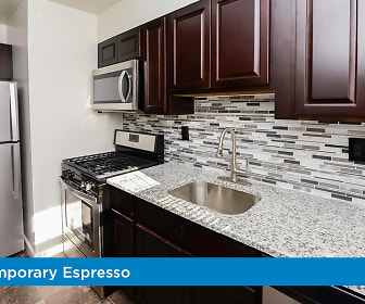 kitchen with stainless steel appliances, gas range oven, dark flooring, dark brown cabinetry, and light granite-like countertops, Elmwood Village Apartments & Townhomes