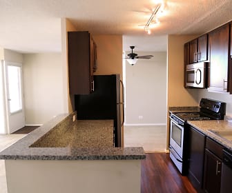 kitchen featuring a ceiling fan, stainless steel microwave, refrigerator, electric range oven, dishwasher, dark granite-like countertops, dark brown cabinets, and light hardwood flooring, Riley Towers Apartments &Townhomes