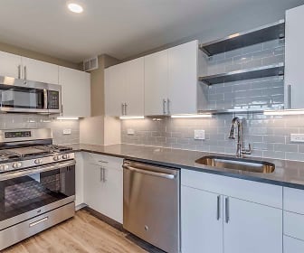 kitchen with stainless steel appliances, gas range oven, white cabinetry, dark countertops, and light parquet floors, Yorktown Apartments
