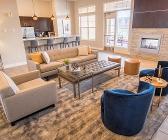 living room with natural light, a kitchen breakfast bar, and refrigerator, Skye at Arbor Lakes Apartments