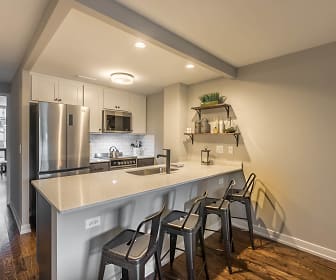 kitchen featuring natural light, a kitchen breakfast bar, beamed ceiling, stainless steel appliances, white cabinetry, dark parquet floors, and light countertops, The Edge @ Sheridan