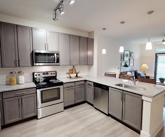 kitchen with electric range oven, stainless steel appliances, dark brown cabinetry, light hardwood floors, pendant lighting, and light stone countertops, The Kirkwood Apartments