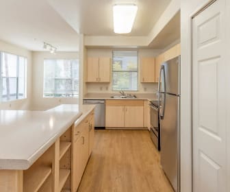 kitchen with a healthy amount of sunlight, a kitchen island, refrigerator, dishwasher, range oven, white cabinetry, light hardwood flooring, and light countertops, Archstone Fremont Center