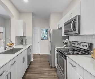 kitchen with stainless steel microwave, electric range oven, dishwasher, light countertops, white cabinetry, and dark hardwood flooring, Camden Governors Village