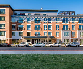 view of building exterior featuring a lawn, Lofts at Kendall Square