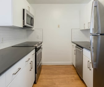 kitchen with electric range oven, stainless steel refrigerator, dishwasher, microwave, dark countertops, white cabinetry, and light hardwood floors, Cronin's Landing