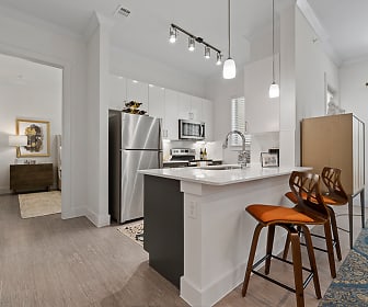 kitchen with a kitchen bar, stainless steel refrigerator, range oven, microwave, white cabinetry, light countertops, pendant lighting, and light parquet floors, The Luxe at Mercer Crossing