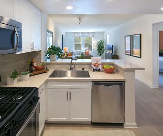 kitchen with natural light, stainless steel appliances, white cabinetry, light hardwood floors, and light countertops, Franklin Street