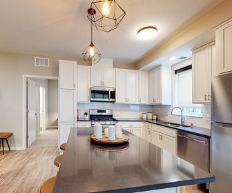 kitchen with stainless steel appliances, range oven, white cabinetry, light hardwood flooring, dark countertops, and pendant lighting, The Morrison