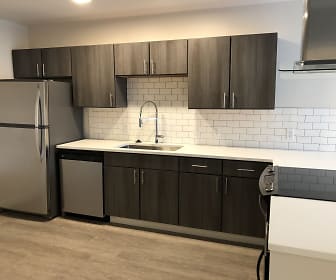 kitchen featuring electric range oven, refrigerator, dishwasher, fume extractor, light countertops, light parquet floors, and dark brown cabinets, The Terminal Building