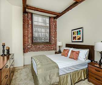 bedroom with wood beam ceiling and exposed bricks, Bigelow Commons