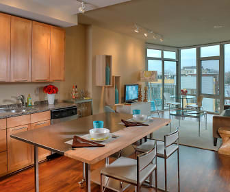 kitchen featuring a healthy amount of sunlight, TV, dishwasher, granite-like countertops, light brown cabinetry, and light hardwood flooring, View 14
