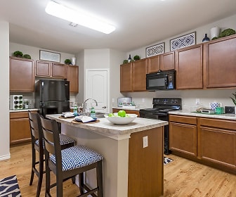 kitchen featuring a center island, stainless steel refrigerator, range oven, microwave, light countertops, light hardwood flooring, and brown cabinetry, Solaire