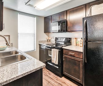 kitchen with refrigerator, electric range oven, microwave, light granite-like countertops, dark brown cabinets, and light hardwood flooring, Stoney Brooke