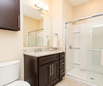 full bathroom featuring tile flooring, mirror, shower booth, toilet, and vanity, The Point at Hudson