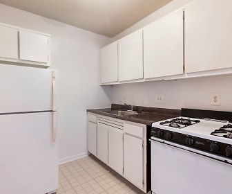 kitchen with gas range oven, refrigerator, white cabinetry, dark countertops, and light tile floors, Park Pleasant Apartments