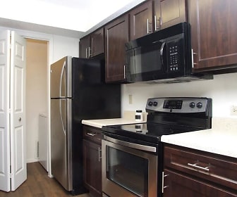 kitchen with stainless steel refrigerator, electric range oven, microwave, granite-like countertops, dark hardwood floors, and dark brown cabinetry, Sherwood Apartments