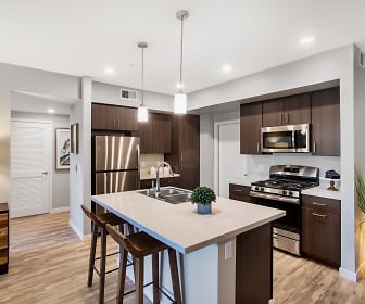 kitchen featuring gas range oven, stainless steel appliances, light flooring, dark brown cabinetry, light countertops, and pendant lighting, Harvest at Damonte Ranch