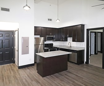 kitchen with a ceiling fan, a center island, stainless steel appliances, range oven, dark brown cabinetry, light granite-like countertops, pendant lighting, and light hardwood flooring, P & P Mill Apartments