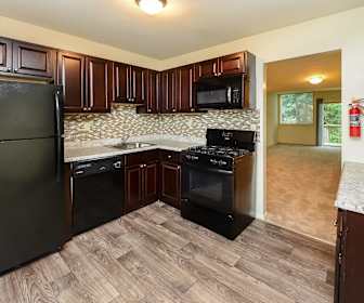 kitchen with gas range oven, refrigerator, dishwasher, microwave, dark brown cabinets, light stone countertops, and light parquet floors, Briarwood Apartments & Townhomes