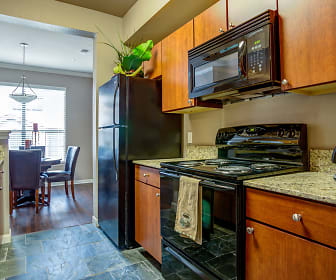 kitchen featuring natural light, refrigerator, dishwasher, electric range oven, microwave, light tile floors, pendant lighting, light granite-like countertops, and brown cabinets, Ranch at Pinnacle Point