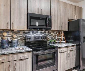 kitchen with stainless steel appliances, electric range oven, dark floors, light granite-like countertops, and brown cabinetry, Centre Pointe