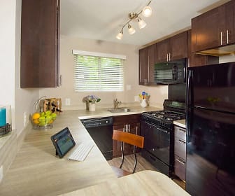 kitchen featuring a healthy amount of sunlight, refrigerator, gas range oven, dishwasher, microwave, light countertops, and dark brown cabinets, Stevenson Lane