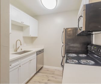 kitchen with stainless steel dishwasher, microwave, light hardwood flooring, white cabinets, and light countertops, Skyline Heights