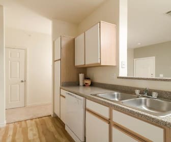 kitchen featuring electric range oven, dishwasher, white cabinetry, light hardwood flooring, and dark granite-like countertops, Villa du Lac