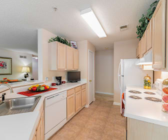kitchen with TV, dishwasher, white cabinetry, light countertops, and light tile flooring, Keswick Village