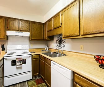 kitchen featuring electric range oven, dishwasher, fume extractor, light countertops, brown cabinets, and dark floors, Riverwind Apartment Homes